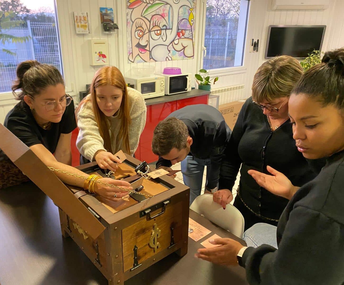 Une équipe de coworkers résolvant une escape box en entreprise. Location d'escape box à domicile